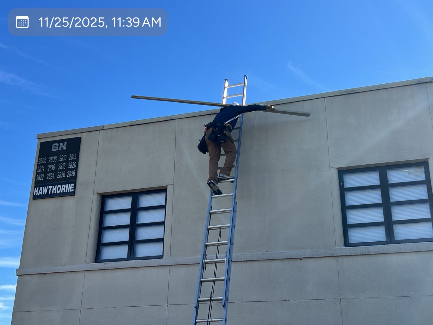 MVP crew member carrying new coping metal to a commercial roof edge